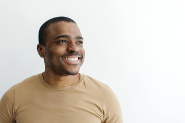 Closeup portrait of smiling African American man looking away with a hopeful and content...