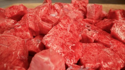 Butcher preparing fresh pieces of red meat on cutting board