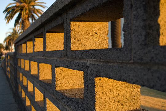 Fototapeta A cinder block brick wall bathed in golden light