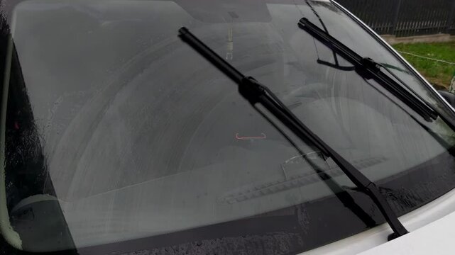 A car with a windshield wiper blade on the windshield