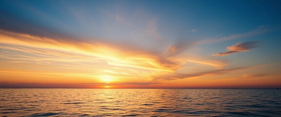Fototapeta premium Romantischer Sonnenuntergang über ruhigem Meer mit farbenprächtigem Himmel und weichen Wolken, stimmungsvoll und malerisch.