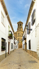 A narrow street with a tall building in the background. Alley with typical andalusian architecture. Baeza, Spain