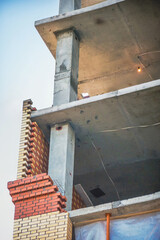 The upward view reveals the architecture of a building under construction with brick and concrete elements.