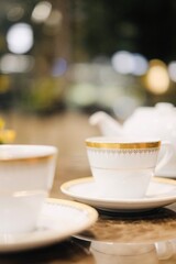 Fine bone china teacups with gold trim and two pots of tea: Taiwanese tie guan yin oolong and Japanese sencha, at the lounge of Montien Surawong, a hotel in Silom - Bang Rak, Bangkok, Thailand