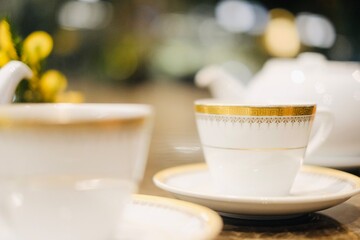Fine bone china teacups with gold trim and two pots of tea: Taiwanese tie guan yin oolong and Japanese sencha, at the lounge of Montien Surawong, a hotel in Silom - Bang Rak, Bangkok, Thailand