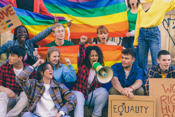 Young activists protesting for equality and lgbtq+ rights with rainbow flags and megaphone