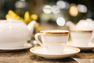 Fine bone china teacups with gold trim and two pots of tea: Taiwanese tie guan yin oolong and Japanese sencha, at the lounge of Montien Surawong, a hotel in Silom - Bang Rak, Bangkok, Thailand