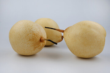 Three pears lie on a white background. Snow pear.