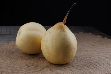 Two pears are lying on burlap. Snow pear.