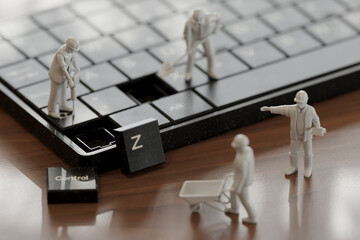Miniature figures working on a computer keyboard in a 3D conceptual scene
