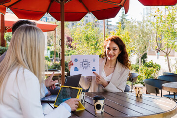 Businesswomen women collaborating outside cafe, reviewing ai strategy with chip diagram highlighting data transmission and computational processing