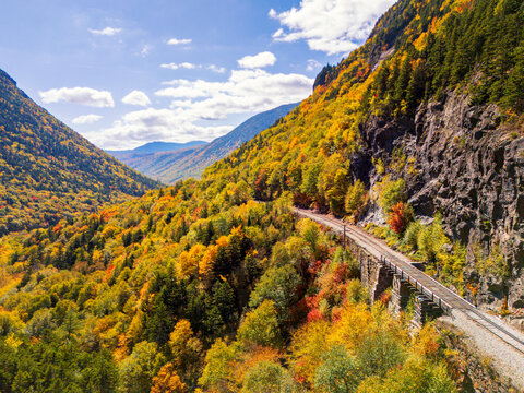 Aerial view of Crawford Notch Railroad in White Mountain National Forest, New Hampshire, showcasing vibrant fall foliage.