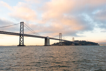 Evening light catching Bay Bridge and calm water as seen during San Francisco ferry ride on May 11, 2019