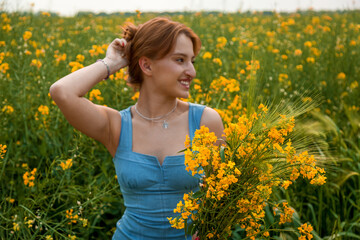 Smiling woman holding rapeseed flowers in summer field