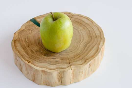 Green apple on the oak stand - Powered by Adobe