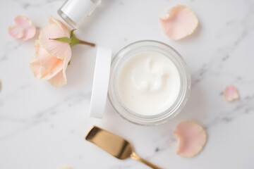 Elegant Beauty Product Display with Cream and Petals on Marble Surface