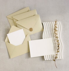 Beige envelope with blank paper card mockup  inside, card mockup and envelopes set top view on beige textured background . Copy space.Wedding invitation mockup, greeting card, holiday concept.