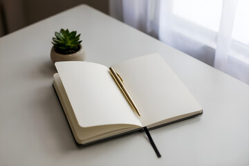 open blank notebook with golden pen