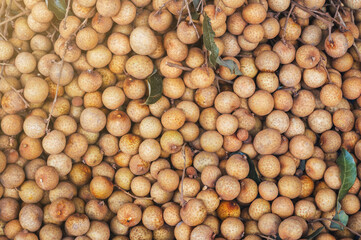 background with ripe longan. Exotic Asian fruits on the counter in market