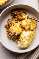 Homemade shepherd’s pie with mashed potatoes and minced meat, served in a cozy rustic kitchen setting. Comforting classic British dish perfect for cozy meals and homestyle food photography.

