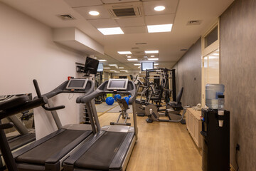 Fototapeta premium Modern hotel fitness gym with equipment and mirrors