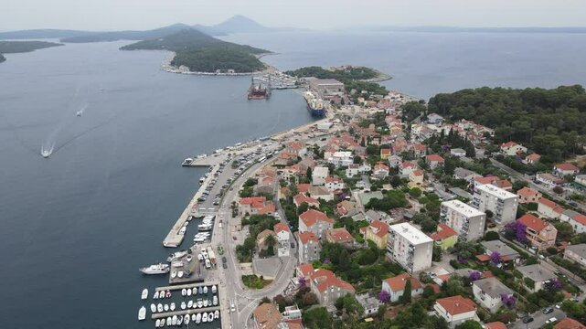 Aerial view of Mali Losinj town on Losinj island, Croatia, Europe. Drone video capturing Mali Losinj town center, harbor, boats and bay of Adriatic Sea.