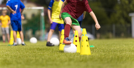 Children Practicing Soccer Drills on Field with Cones During Youth Training Camp