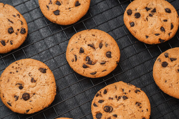 Freshly baked chocolate chip cookies cooling on a wire rack in a kitchen