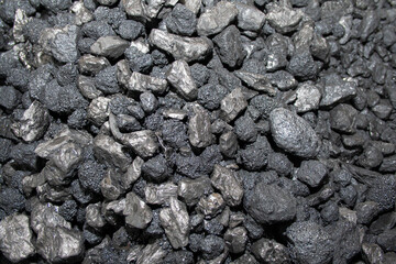 Pile of black coal stones with roughness and bulging on the outside, intended as fuel for domestic or industrial use, extracted from the mining basins of Asturias