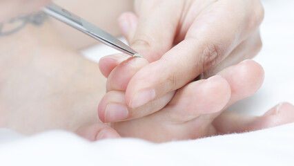 Mother gently holding baby's hand while trimming tiny fingernails with small scissors, prioritizing hygiene and preventing potential scratches for a safe and nurturing experience