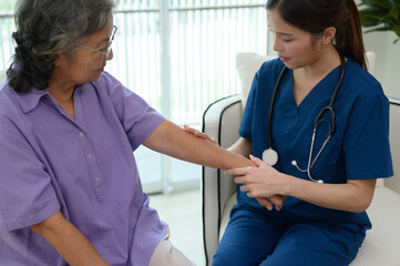 A female doctor is checking the temperature of an elderly patient.