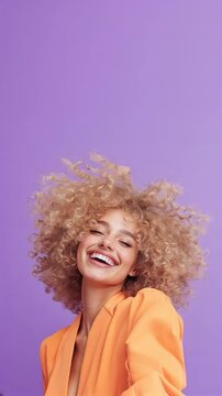 Happy smiling fashion model woman curly hair posing, vivid purple studio background with copy space