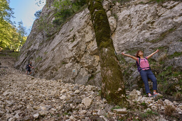 Naklejka premium Woman climbing rocky forest slope