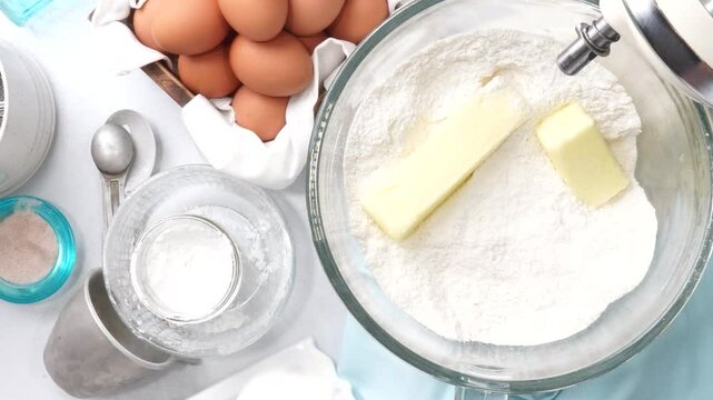 Baking a triple layer light blue cake with buttercream icing.  Decorating a vanilla cake for spring time.  Icing a cake and using coconut and candy eggs to make it look like a robin egg.