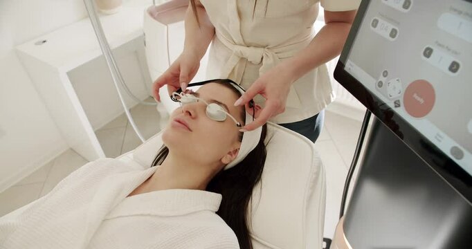 Facial rejuvenation, beauty woman with protective glasses, aesthetic medicine is performing procedure. Woman getting LPG hardware massage at the beauty clinic. Beauty treatment.