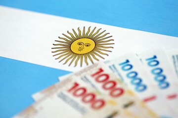 Argentine pesos money bills in big amount lies on Argentina flag close up