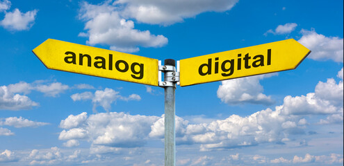 Ein Wegweiser zeigt in unterschiedliche Richtungen und ist beschriftet mit analog und digital -...