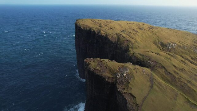 Breathtaking cliffs in the faroe islands rise dramatically from the ocean, showcasing nature's raw beauty and power