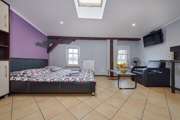 Kolorowy apartament na poddaszu z dużym łóżkiem i aneksem kuchennym