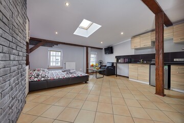 Kolorowy apartament na poddaszu z dużym łóżkiem i aneksem kuchennym