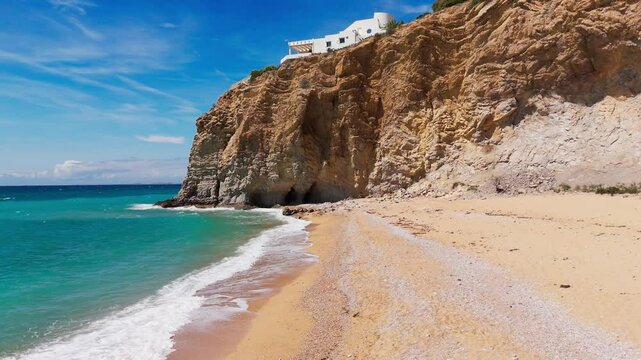 Backtracking drone motion over sandy rocky Mediterranean cove.