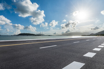 Empty asphalt road and sea with mountain natural landscape on a sunny day