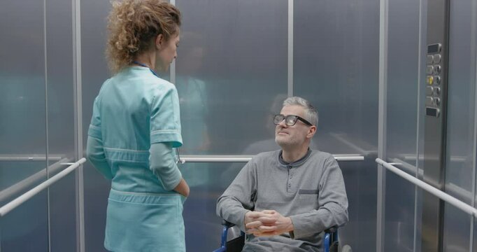 Patient in wheelchair and doctor in the hospital elevator