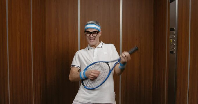 Funny man holding a tennis racket and pretending to play a guitar