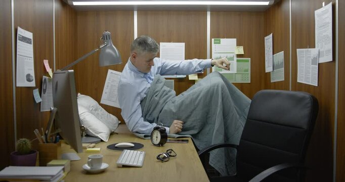 Businessman working and sleeping in his small office