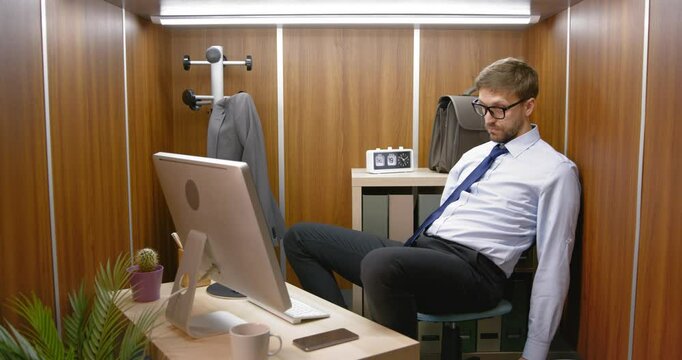 Bored employee sitting in his small office