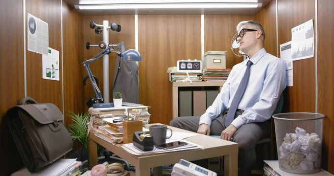 Bored inefficient employee wasting time in his small office