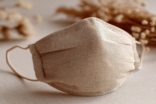 A close-up of a reusable fabric face mask with soft light and natural elements, perfect for showcasing sustainable pandemic protection alternatives, stylish and eco-friendly.