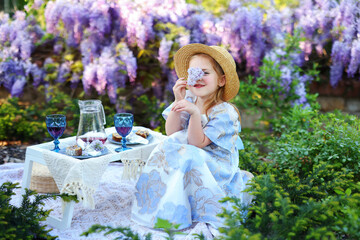 Adorable child enjoying springtime leisure surrounded by blooming purple wisteria vines