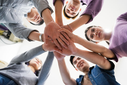 Team members join hands in unity during a collaborative workshop to enhance teamwork and communication skills